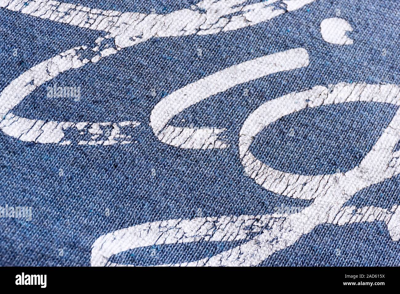 Abstract macro texture background of white typographic print on blue t-shirt Stock Photo