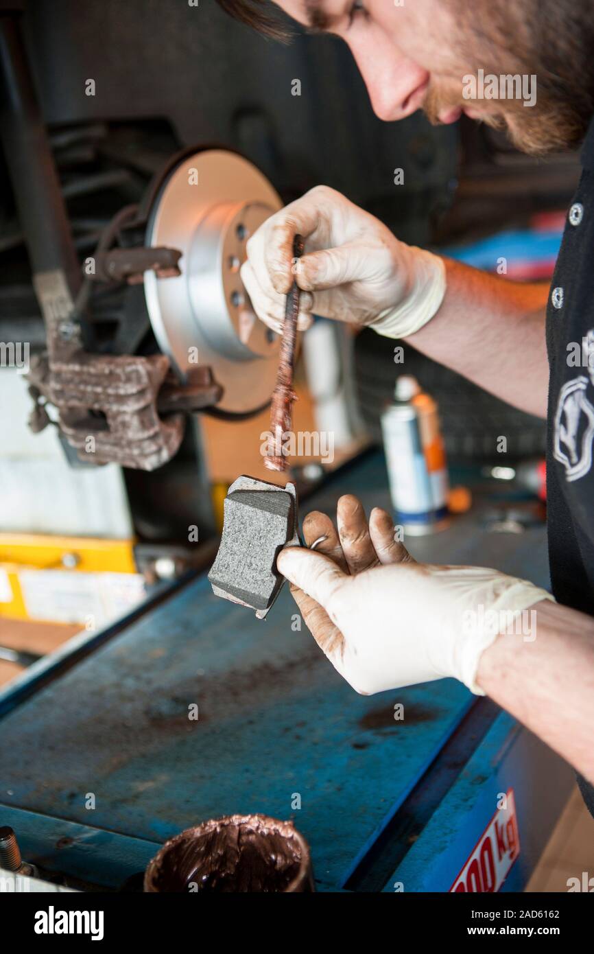 Car servicing. Technician applying copper grease to the rear of new brake  pads prior to fitting to a car during servicing at a vehicle service centre  Stock Photo - Alamy