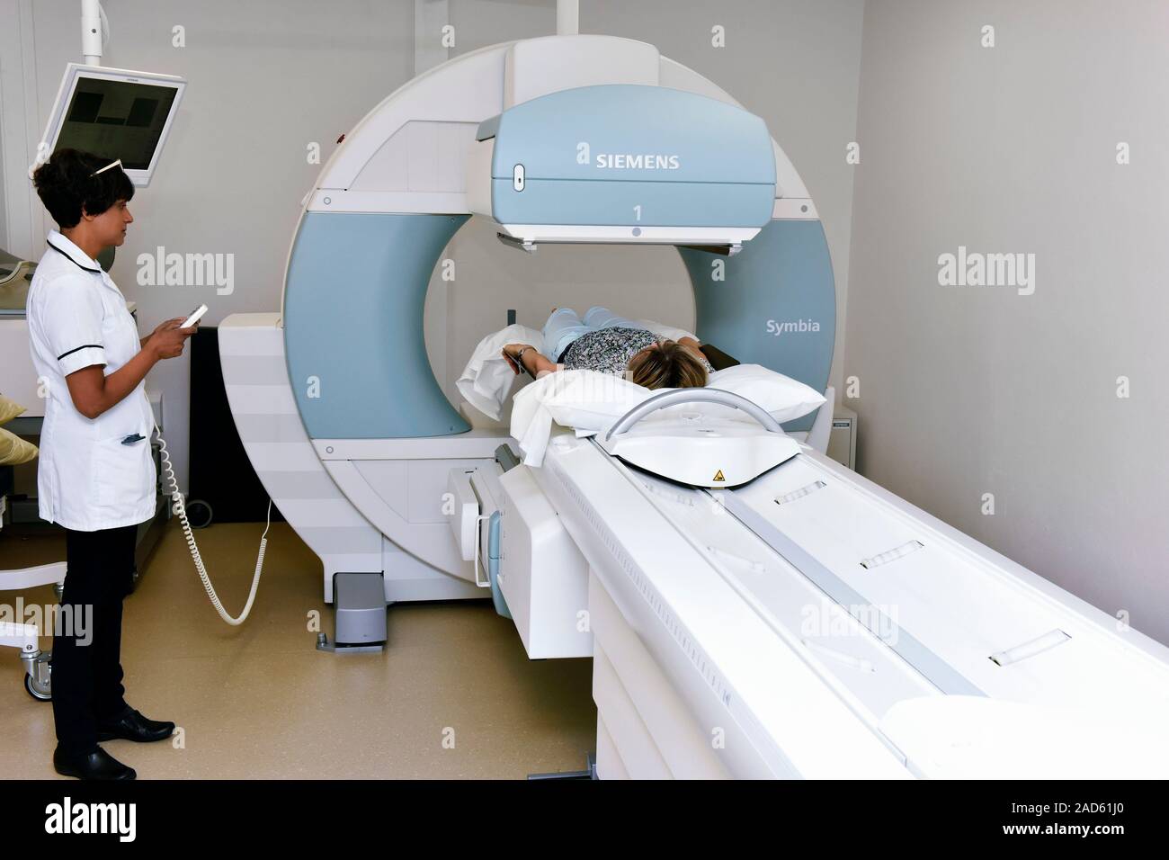 SPECT computed tomography scanning. Radiographer operating a computed ...