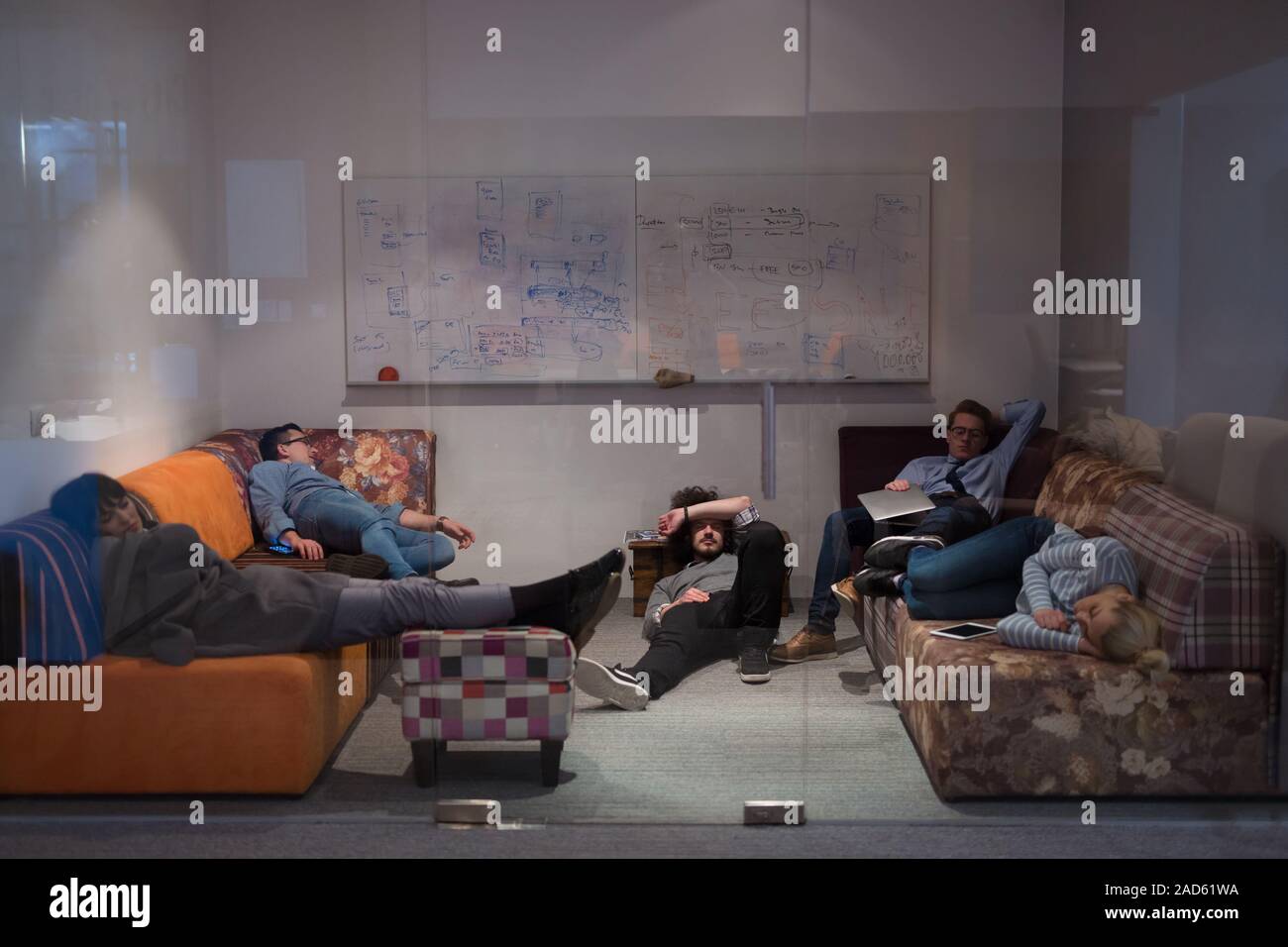 software developers sleeping on sofa in creative startup office Stock Photo