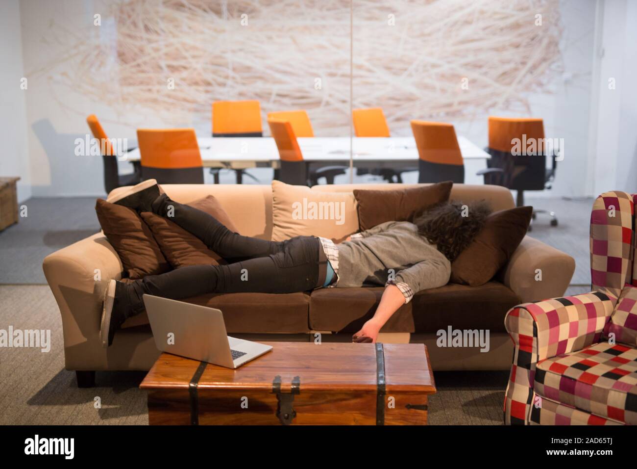 man sleeping on a sofa  in a creative office Stock Photo