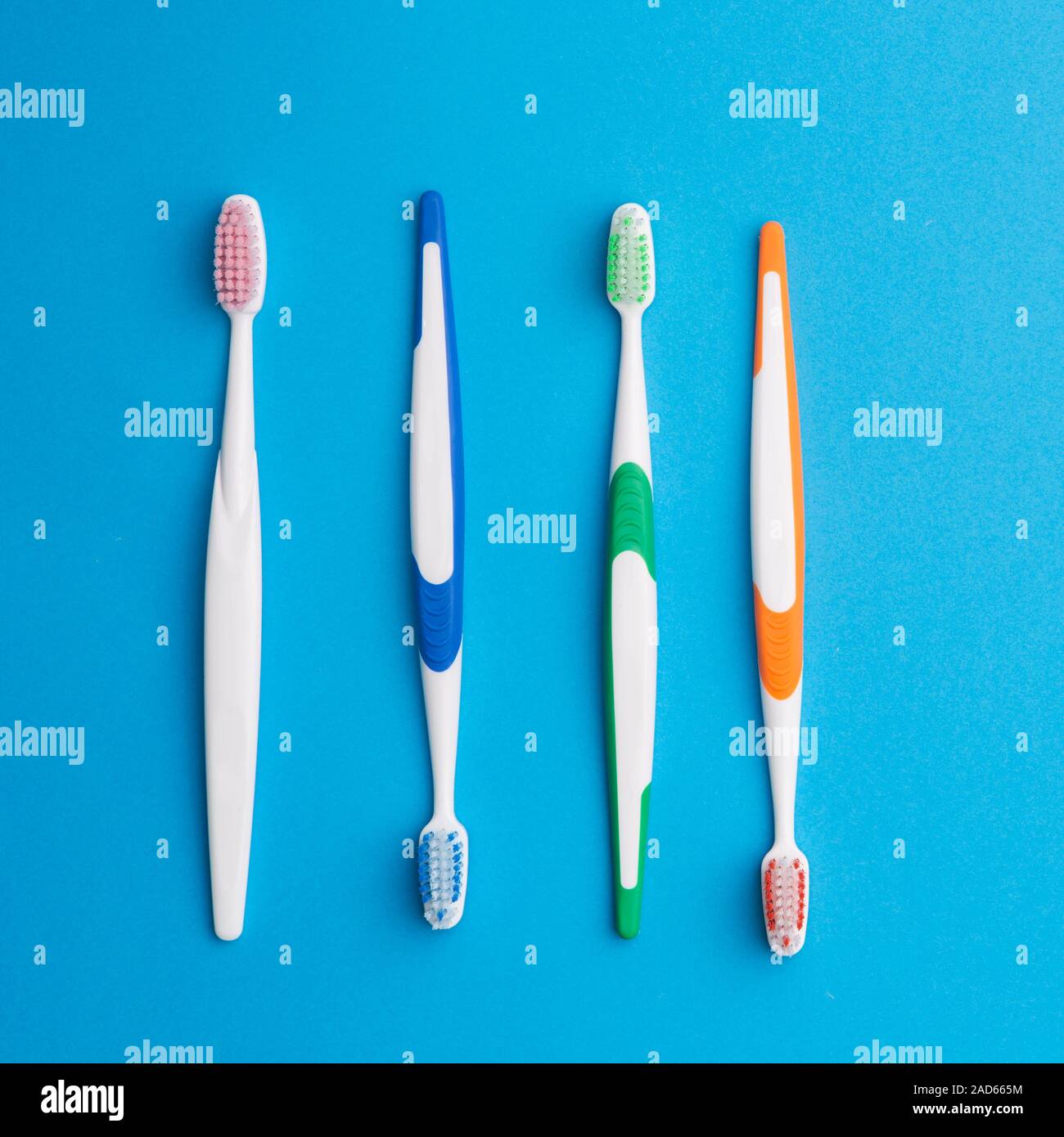 Multicolored toothbrushes on blue background Stock Photo