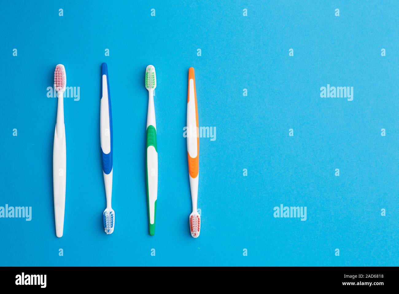 Multi-colored toothbrushes on blue background Stock Photo