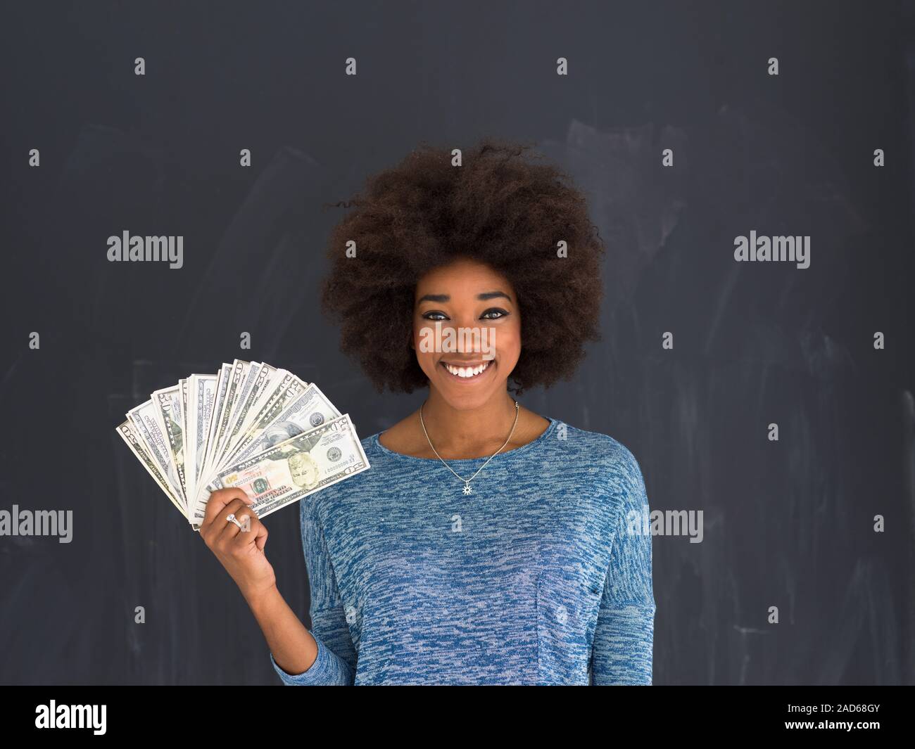 black woman holding money on gray background Stock Photo