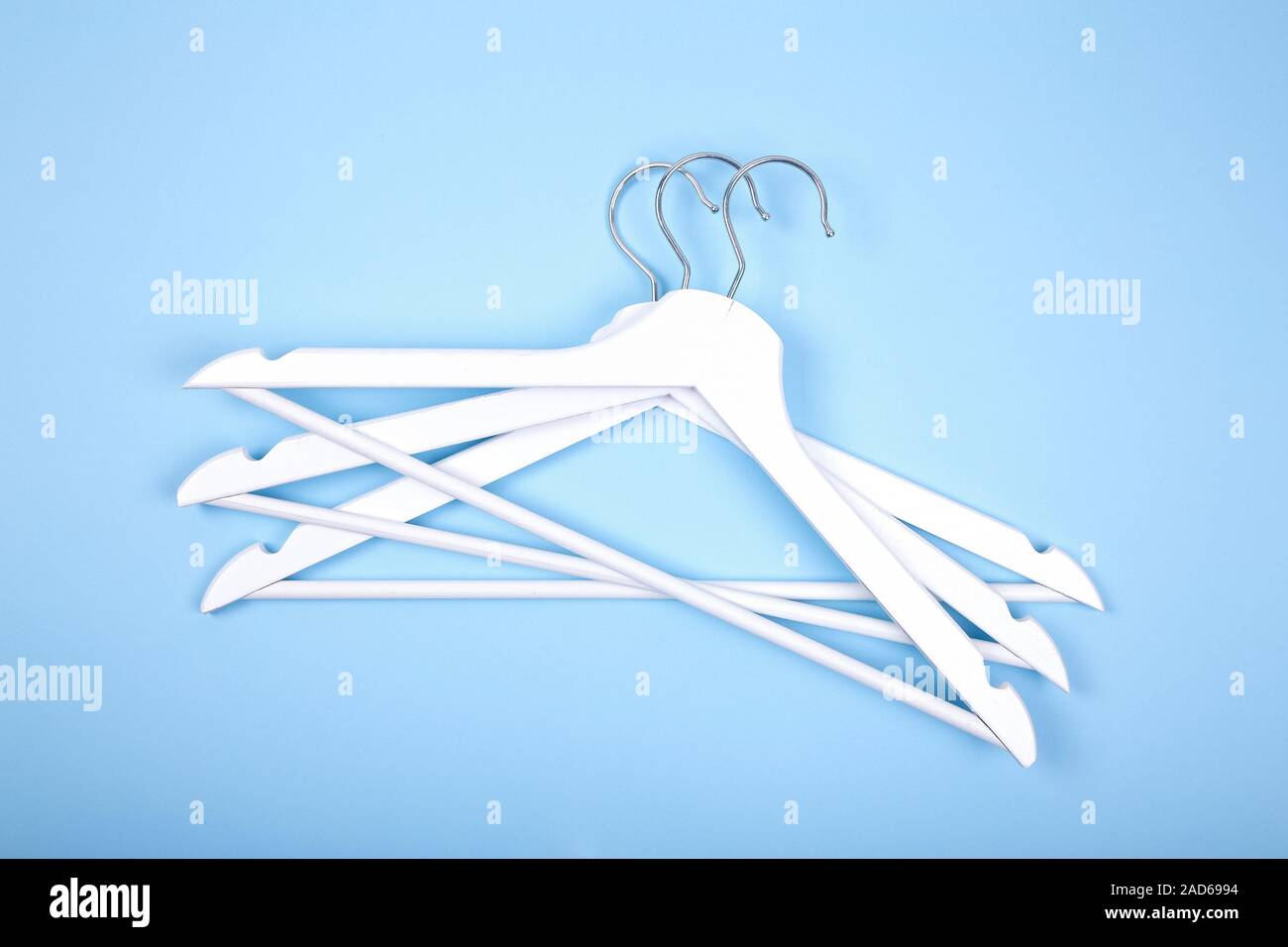 White wooden clothes hanger on blue background Stock Photo