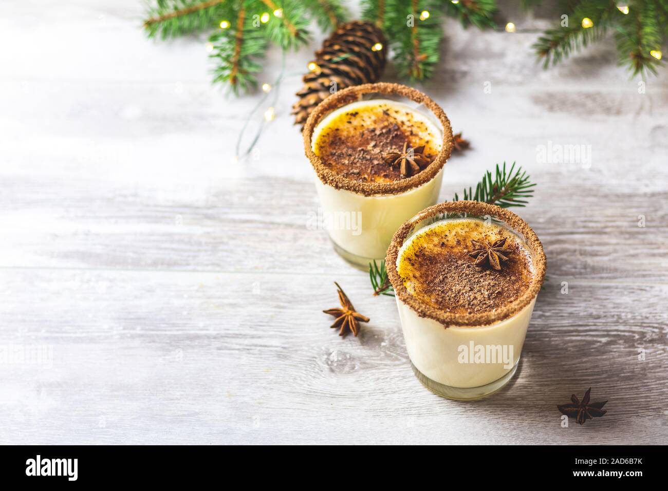 https://c8.alamy.com/comp/2AD6B7K/eggnog-with-cinnamon-and-nutmeg-for-christmas-and-winter-holidays-homemade-eggnog-in-glasses-on-wooden-table-surface-shallow-depth-of-the-field-cop-2AD6B7K.jpg