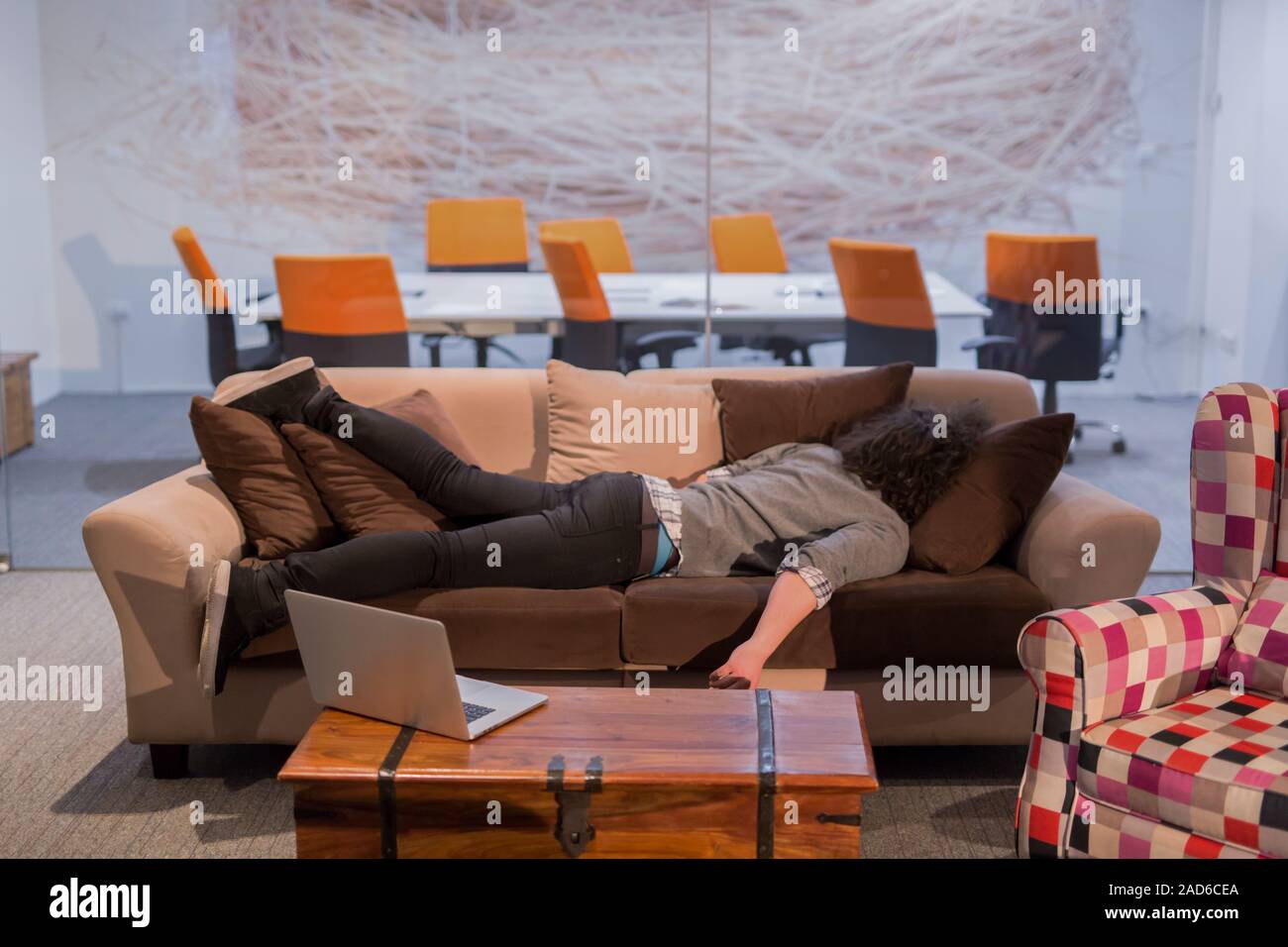 man sleeping on a sofa in a creative office Stock Photo