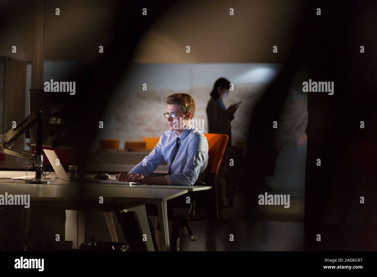 man working on computer in dark office Stock Photo