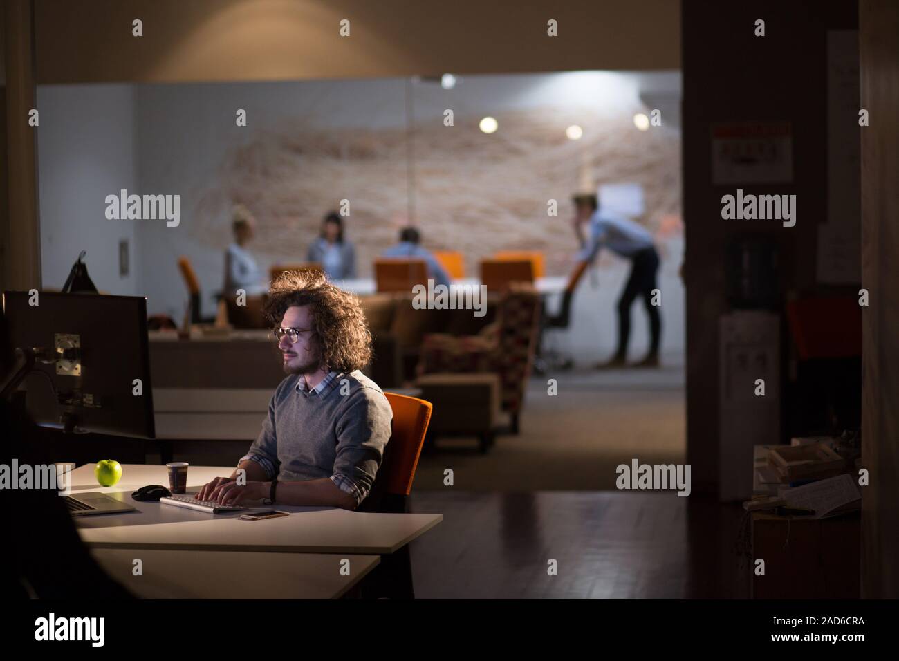man working on computer in dark office Stock Photo