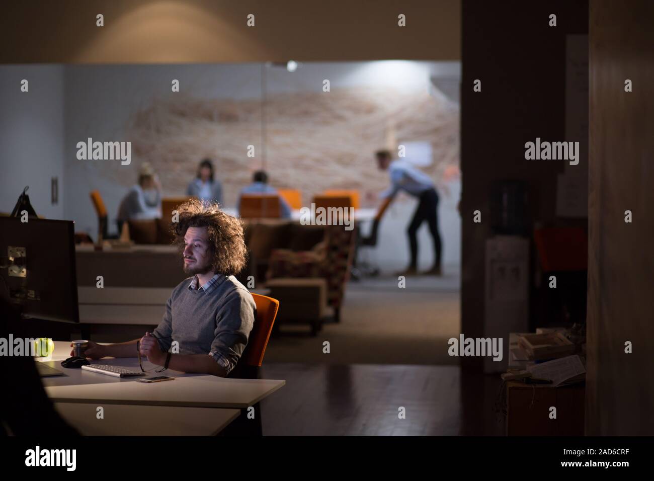 man working on computer in dark office Stock Photo