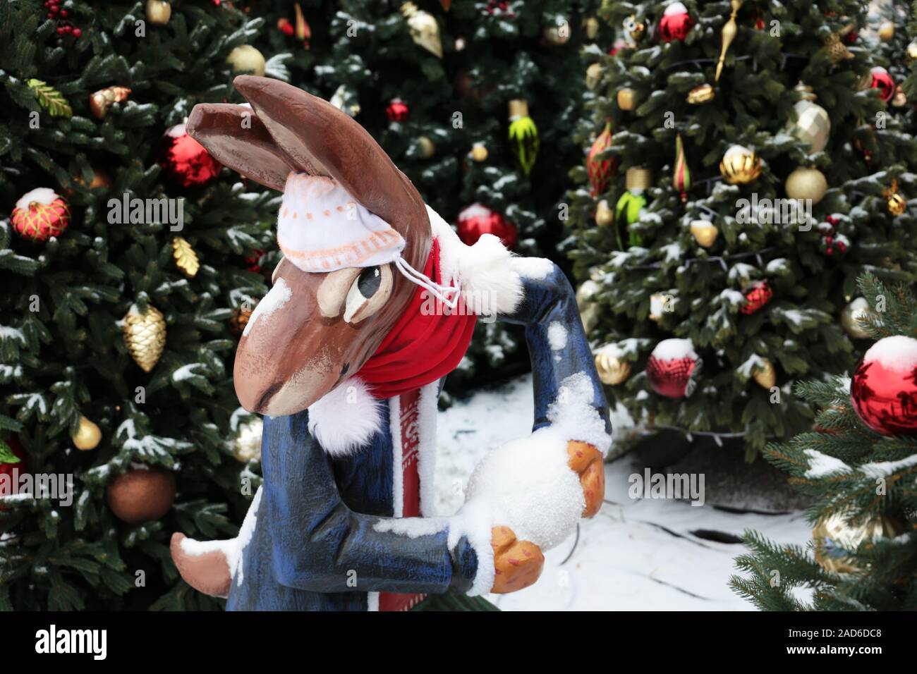 Christmas rabbit with snowball on a winter street, New Year decorations ...