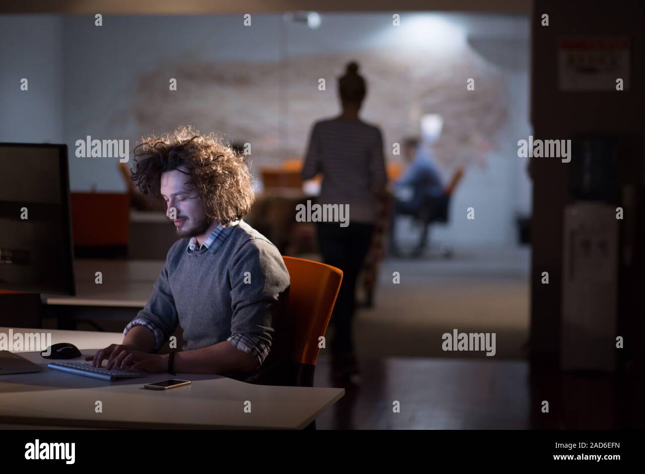 man working on computer in dark office Stock Photo