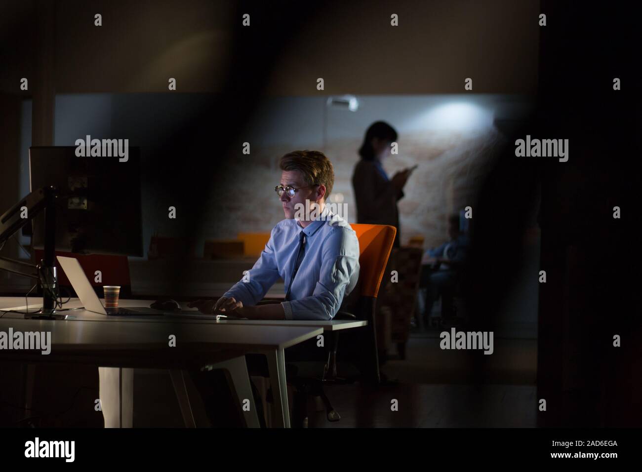 man working on computer in dark office Stock Photo