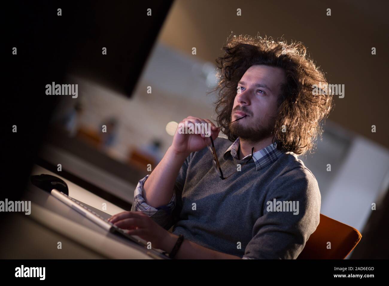 man working on computer in dark office Stock Photo