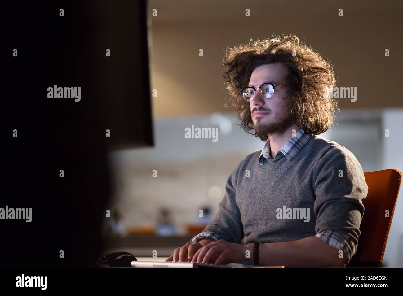 man working on computer in dark office Stock Photo