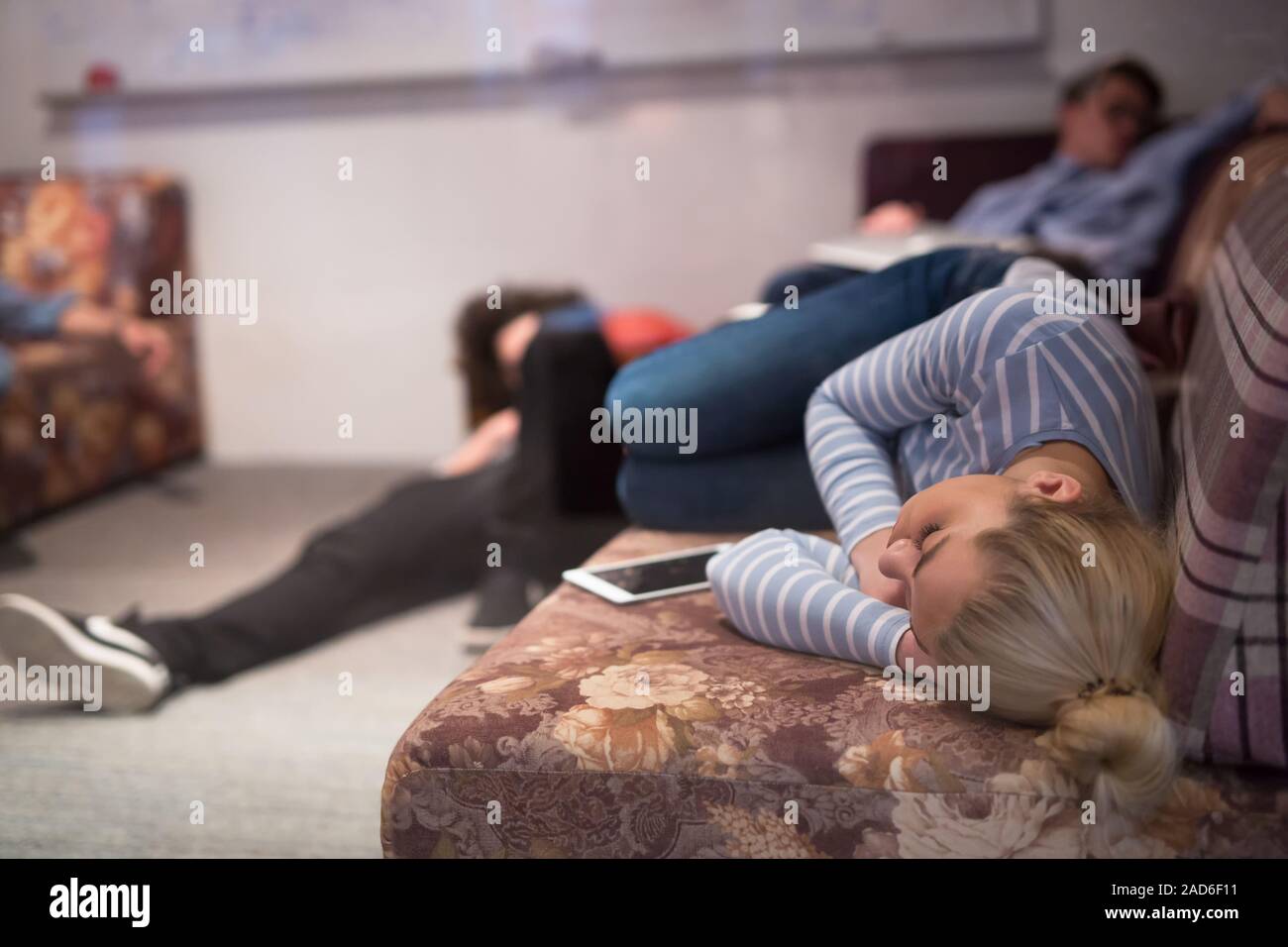 software developers sleeping on sofa in creative startup office Stock Photo