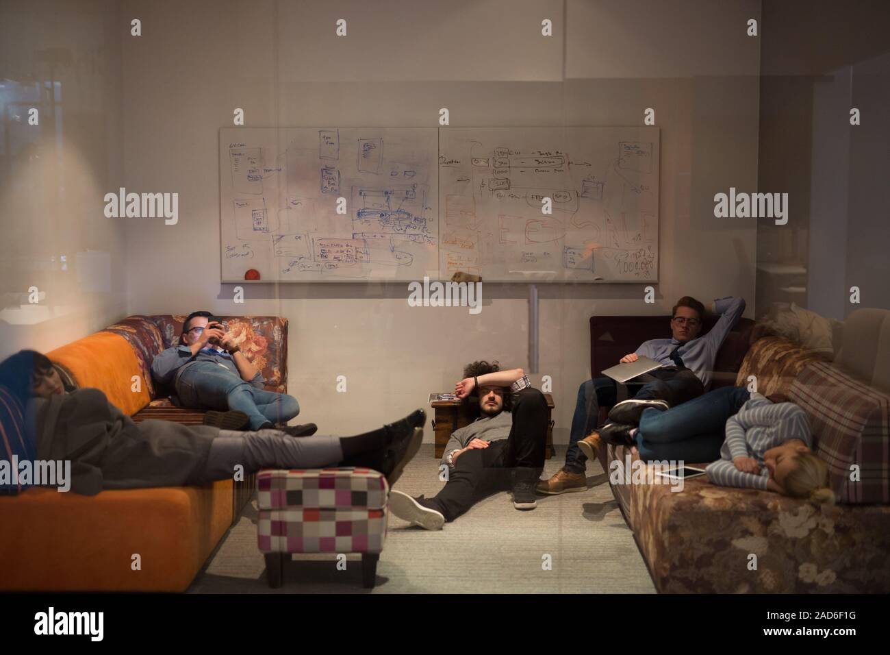 software developers sleeping on sofa in creative startup office Stock Photo