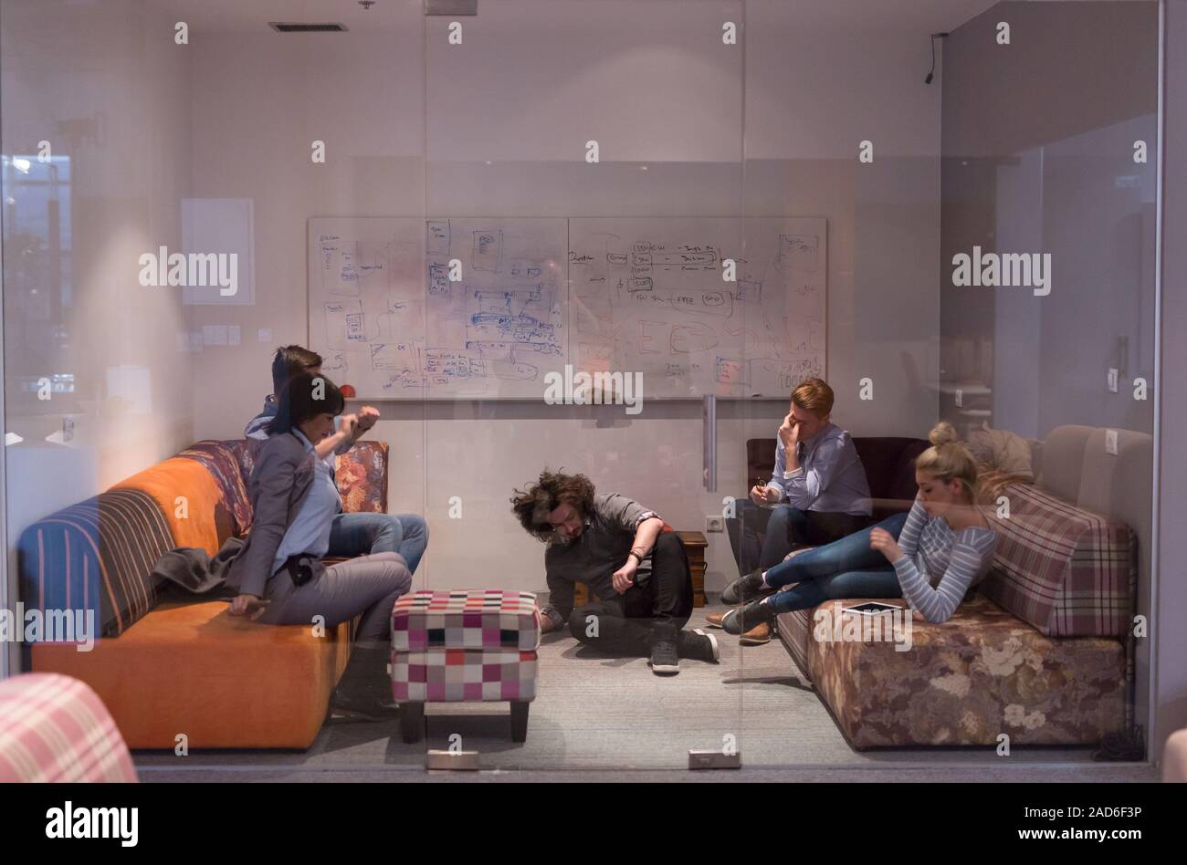 software developers sleeping on sofa in creative startup office Stock Photo