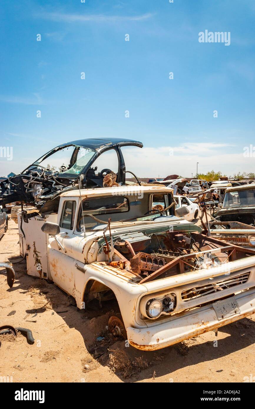 rusty old cars and trucks in a junk yard in the desert in Phoenix
