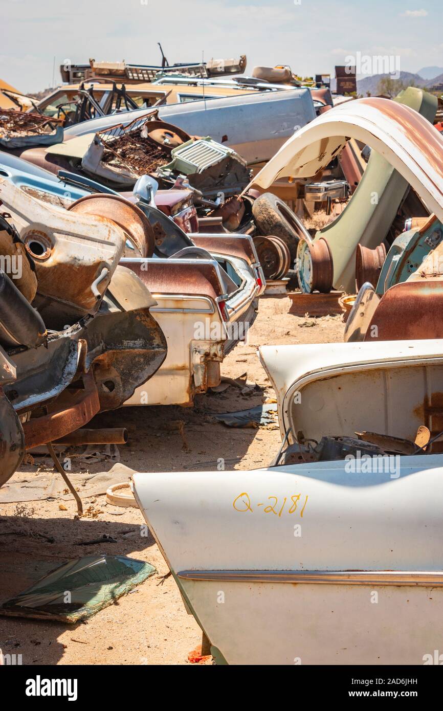 rusty old cars and trucks in a junk yard in the desert in Phoenix