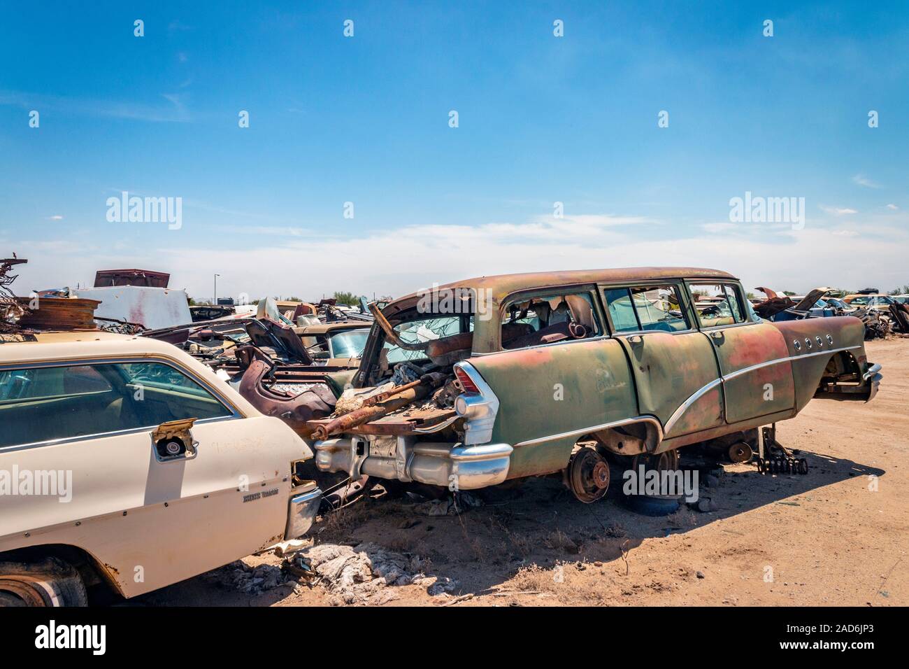 rusty old cars and trucks in a junk yard in the desert in Phoenix