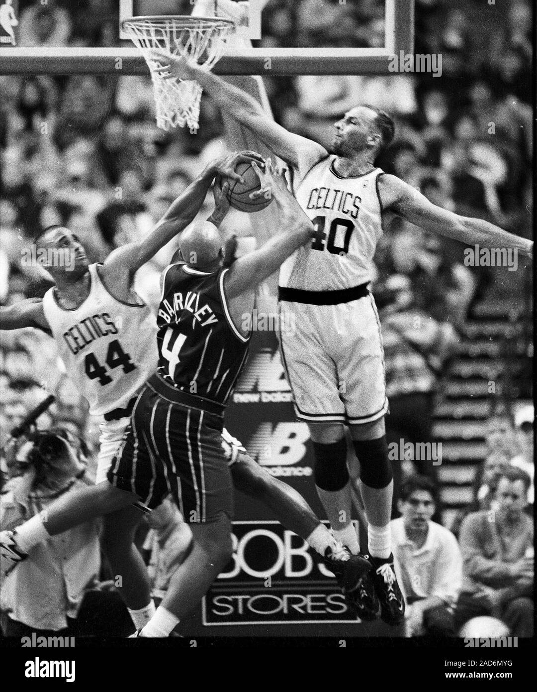 Boston Celtics Rick Fox (left) grabs the ball as Houston Rockets #4 Charles Barkley  tries to shoot on Celtics Dino Rada  during basketball game action against the Boston Celtics at the Fleet Center in Boston Ma USA Nov26,1996 photo by bill belknap Stock Photo