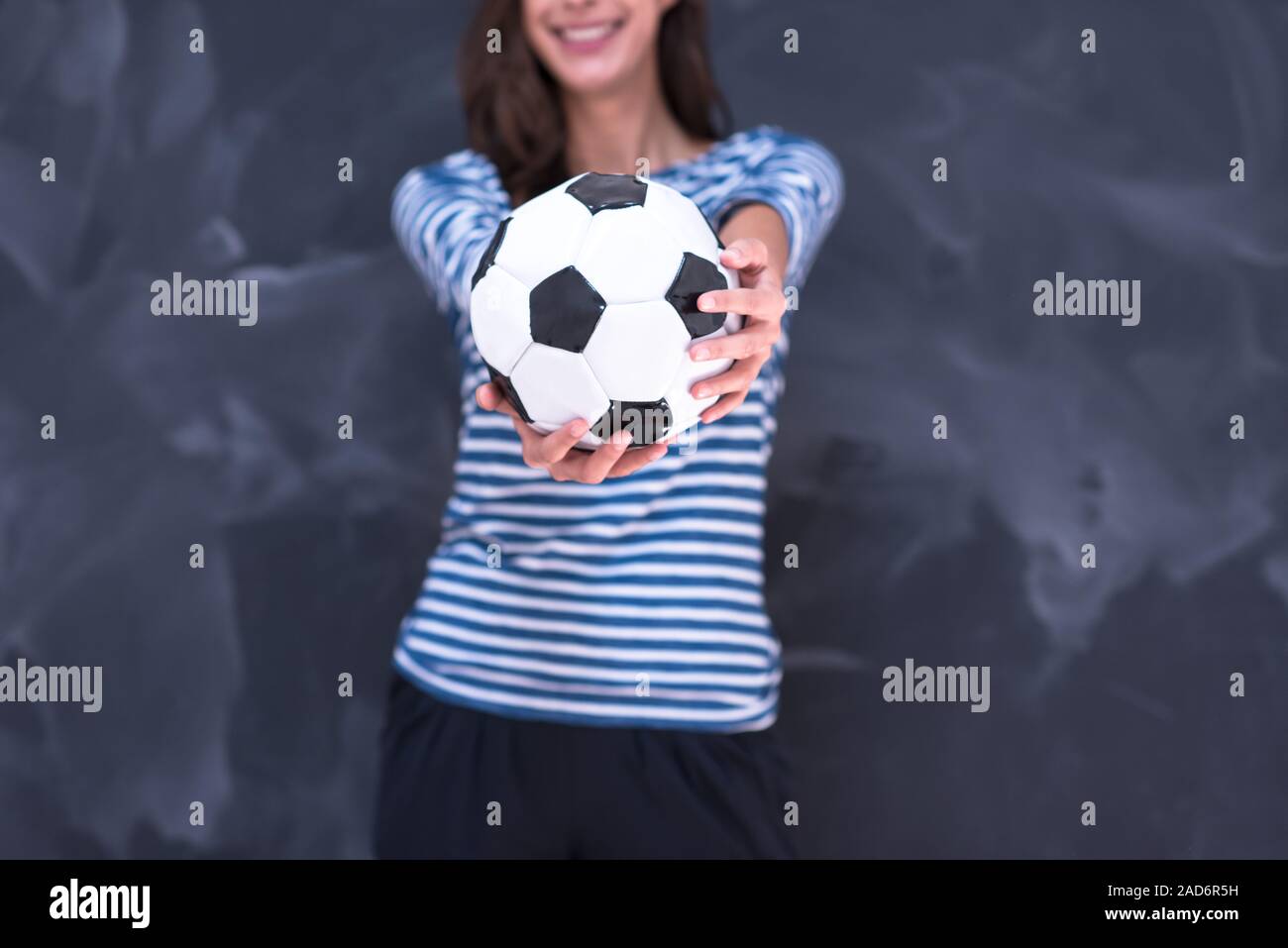 woman holding a soccer ball in front of chalk drawing board Stock Photo ...