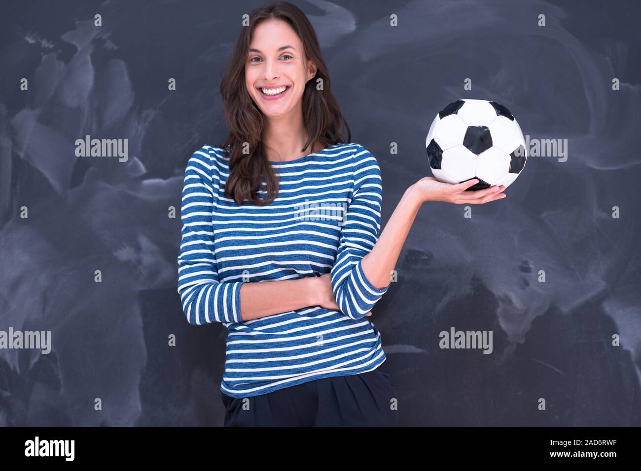 woman holding a soccer ball in front of chalk drawing board Stock Photo ...