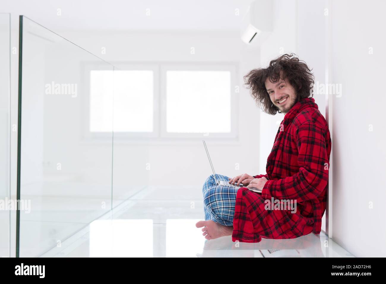 young freelancer in bathrobe working from home Stock Photo