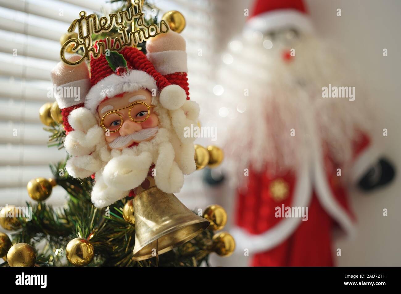 Toy portrait of Santa Claus in glasses and a red hat hanging on the ...