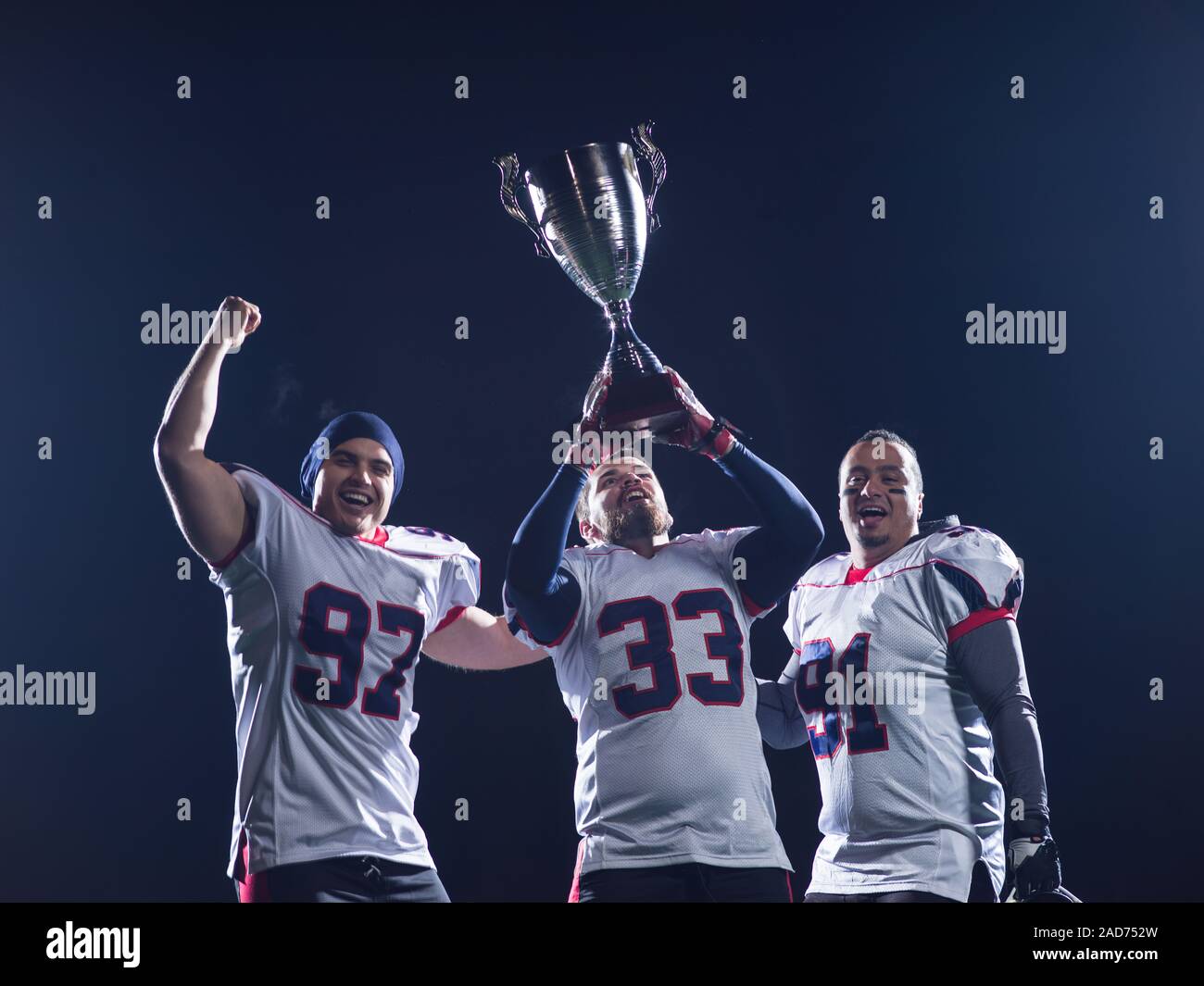 american football team with trophy celebrating victory Stock Photo