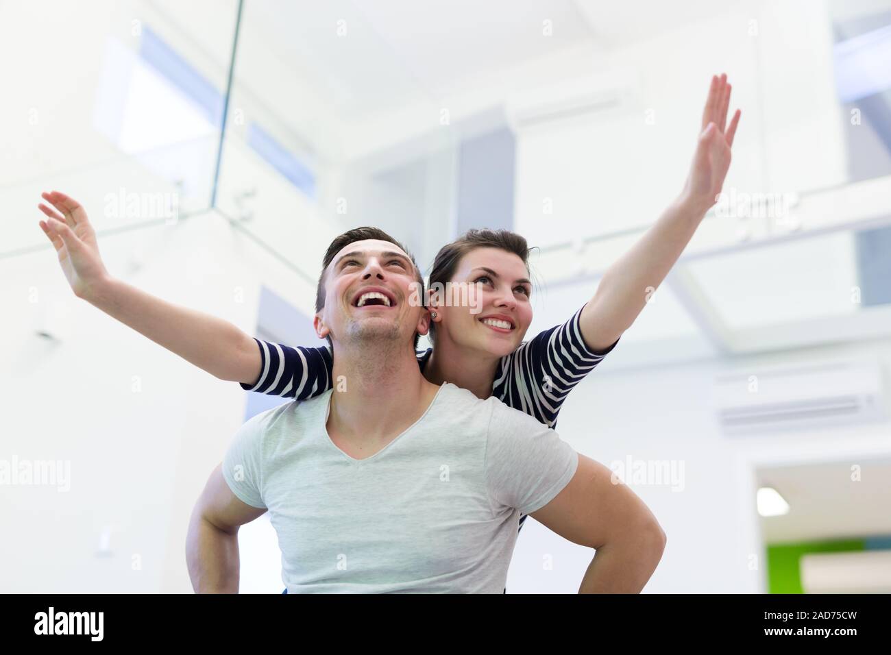 handsome man piggybacking his girlfriend Stock Photo