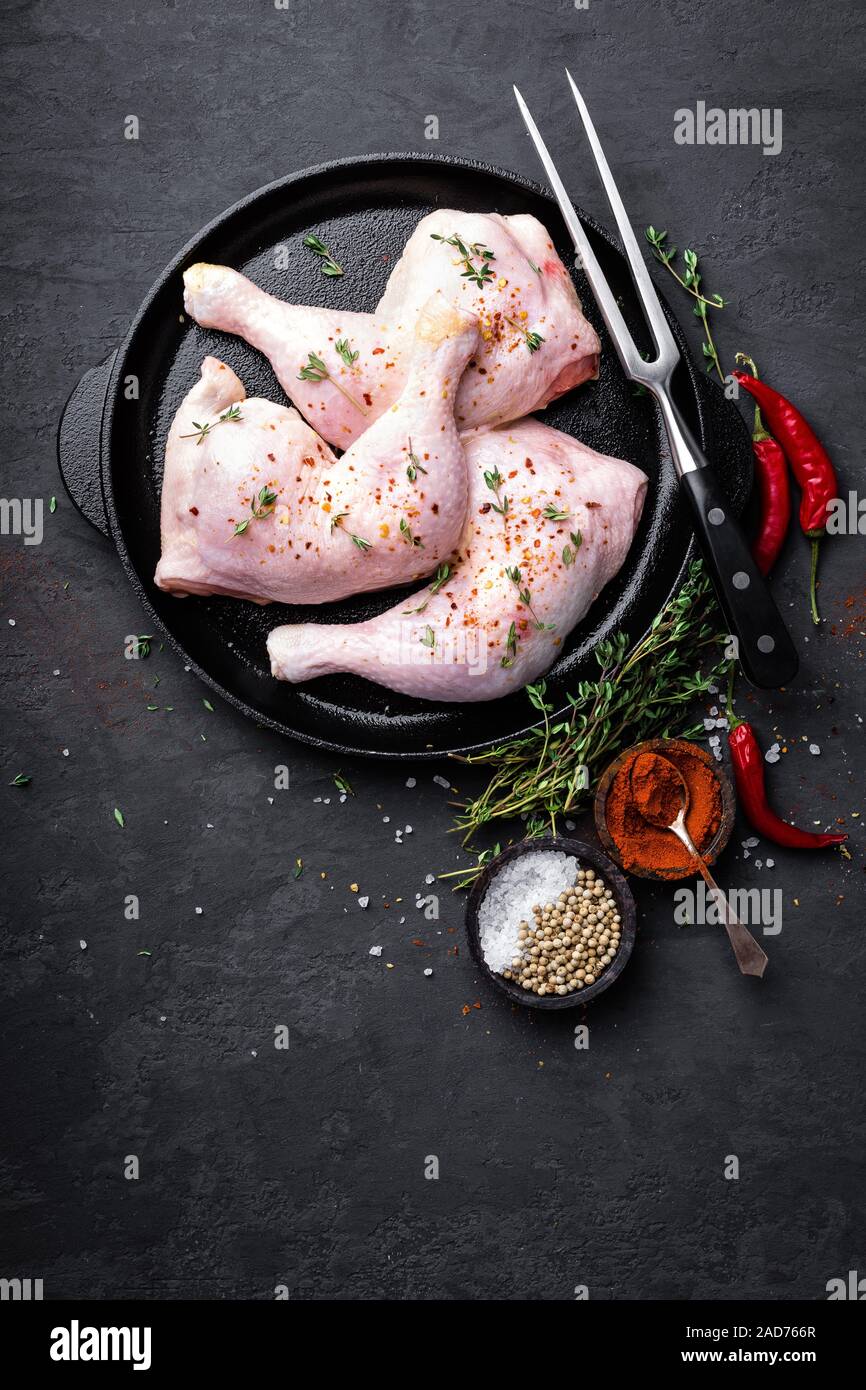 Raw chicken quarters, legs in a pan on a dark background. Top view. Stock Photo