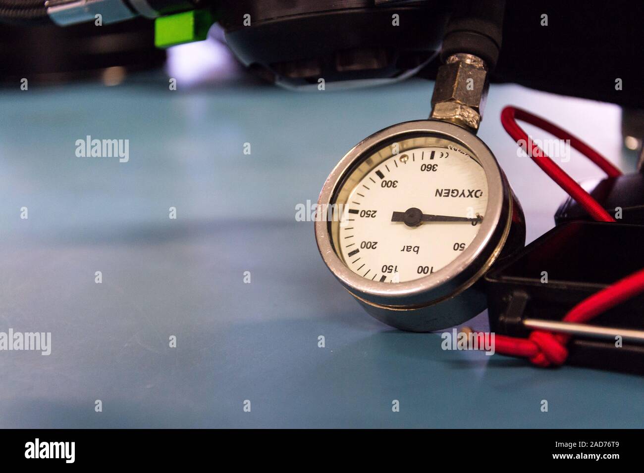 Gas pressure indicator, scuba diving oxygen lying on blue table