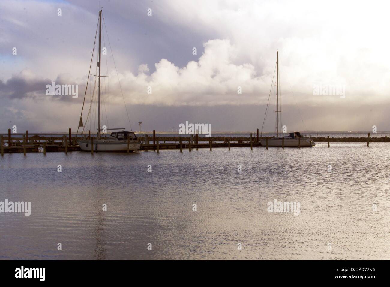 Harbor sunrise with docked sailing ships Stock Photo