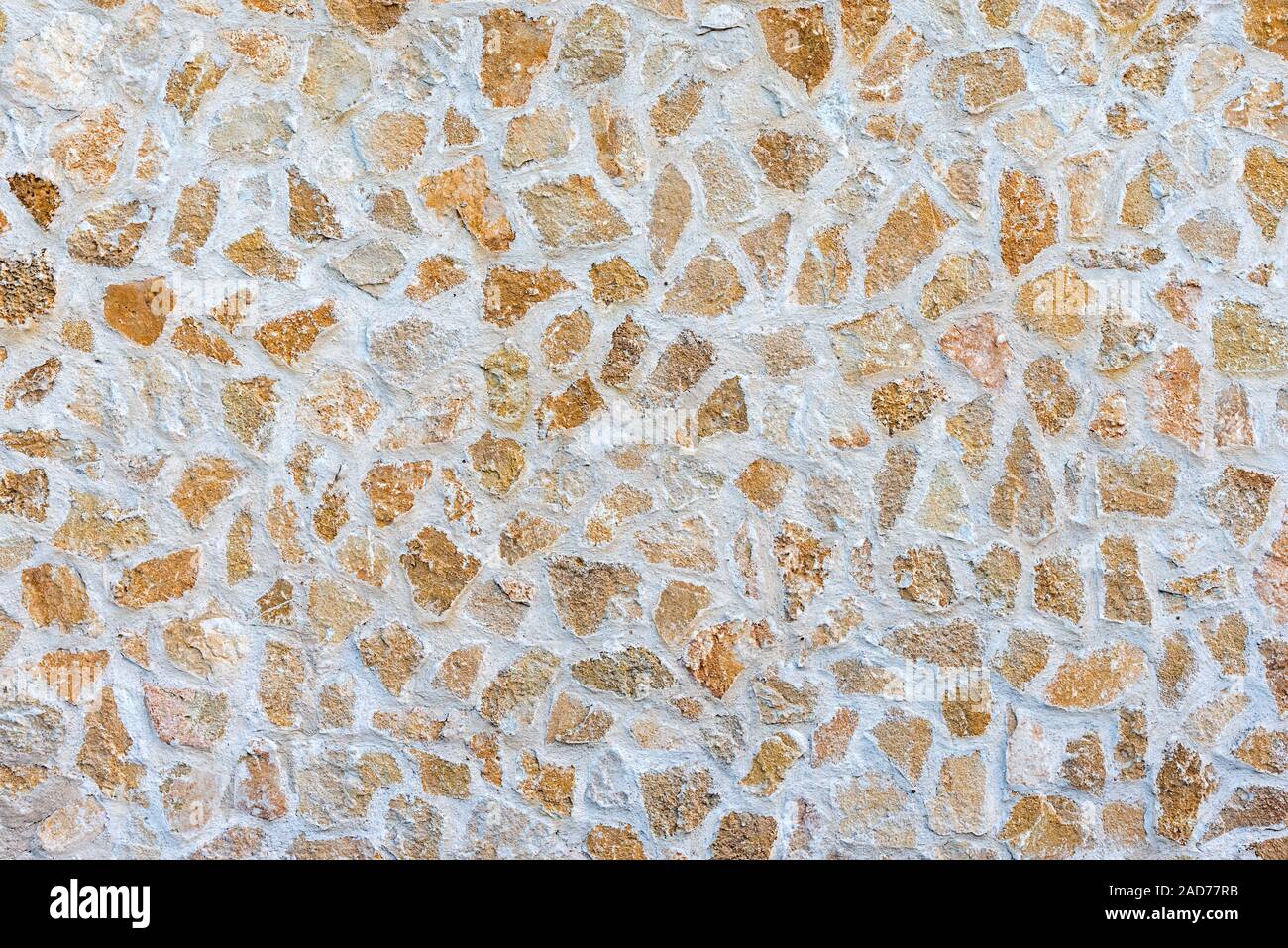 Background from a rough beige natural stone wall Stock Photo
