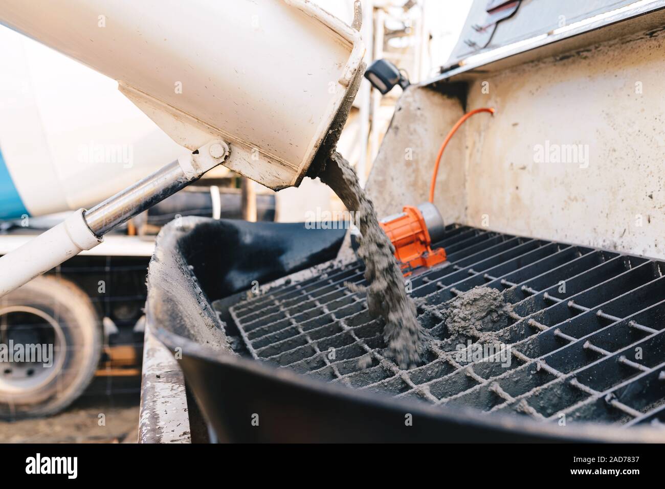 pouring concrete from a concrete mixer to the pump pouring concrete