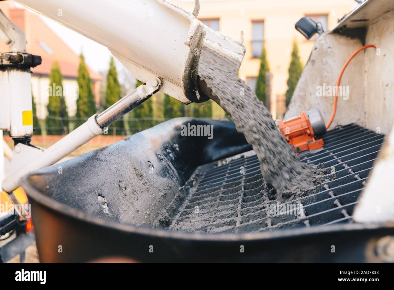 pouring concrete from a concrete mixer to the pump pouring concrete