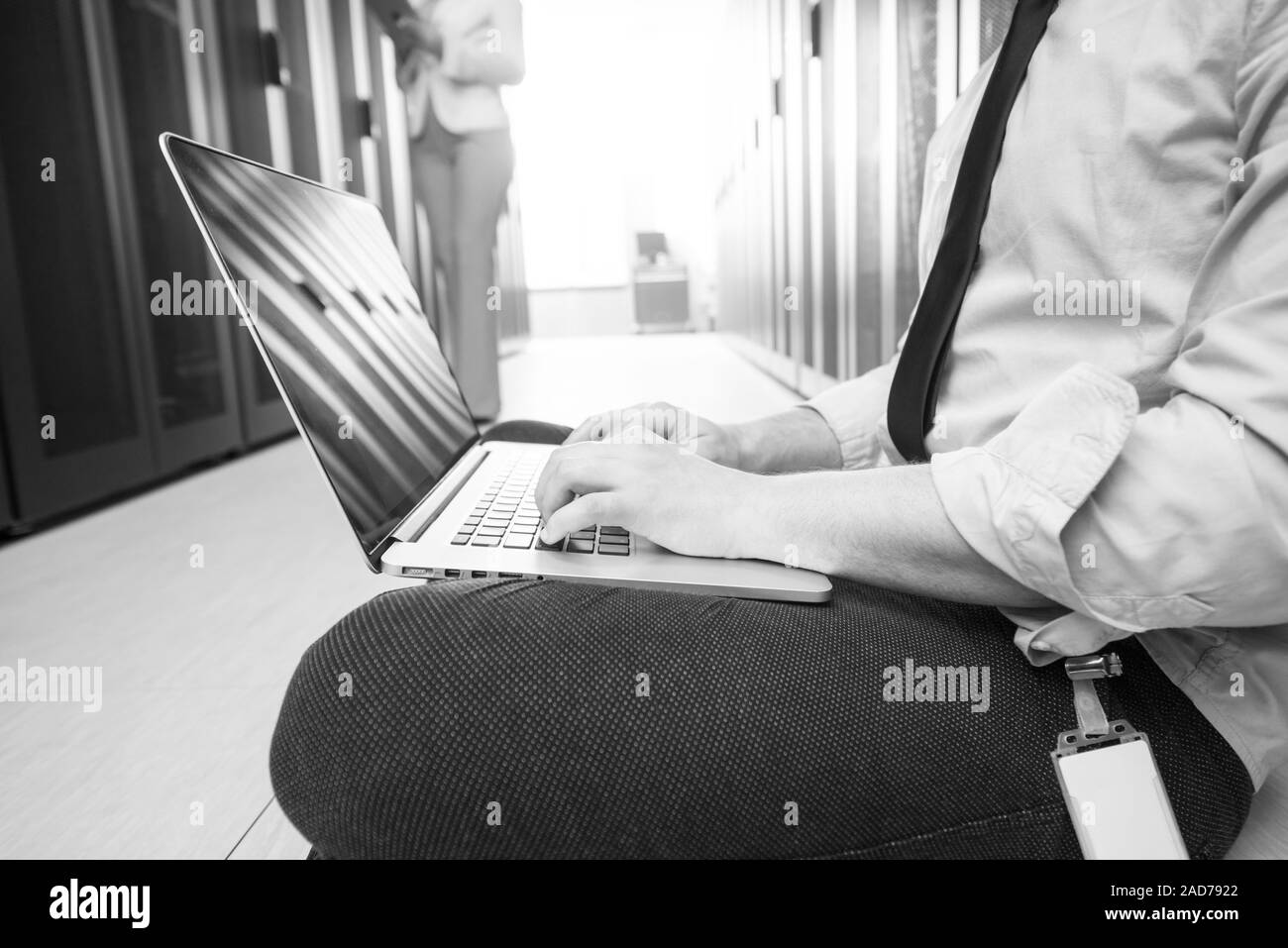 engineer working on a laptop in server room Stock Photo