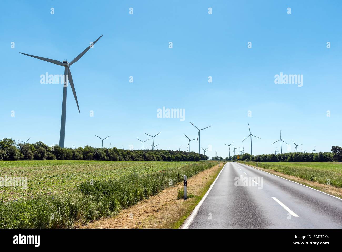 Wind power plants and a country road seen in Germany Stock Photo