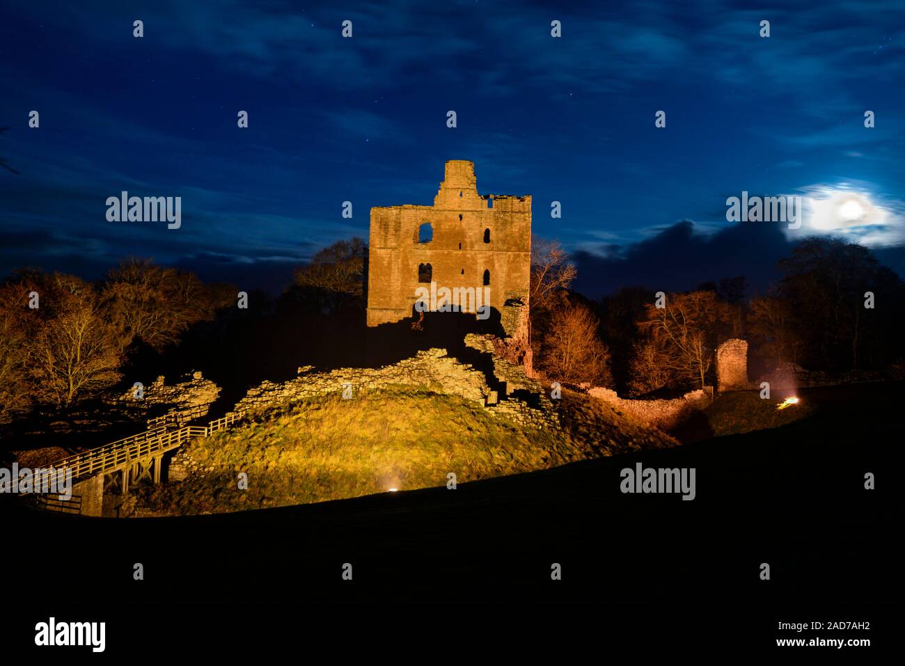 The moon rising over the  inner Bailey and keep of Norham Castle, one of the most important of the English castles on the Scottish border. Stock Photo