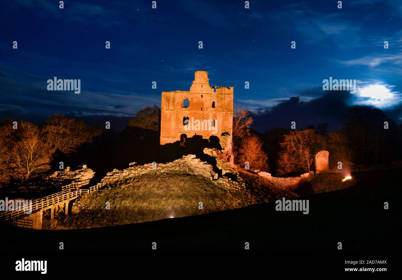 The moon rising over the  inner Bailey and keep of Norham Castle, one of the most important of the English castles on the Scottish border. Stock Photo