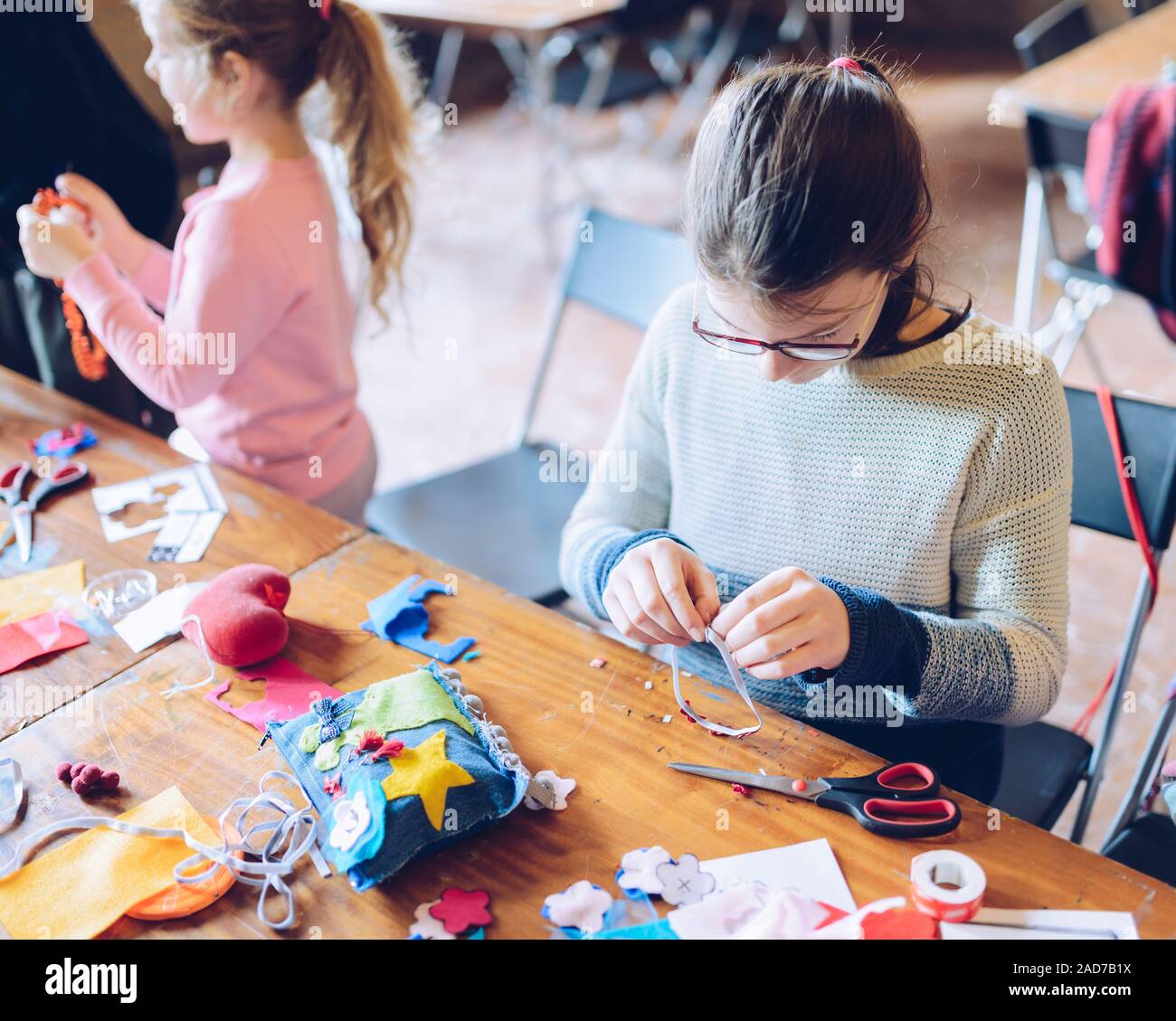tailor art workshops for children - a girl sewing felt decorations Stock Photo