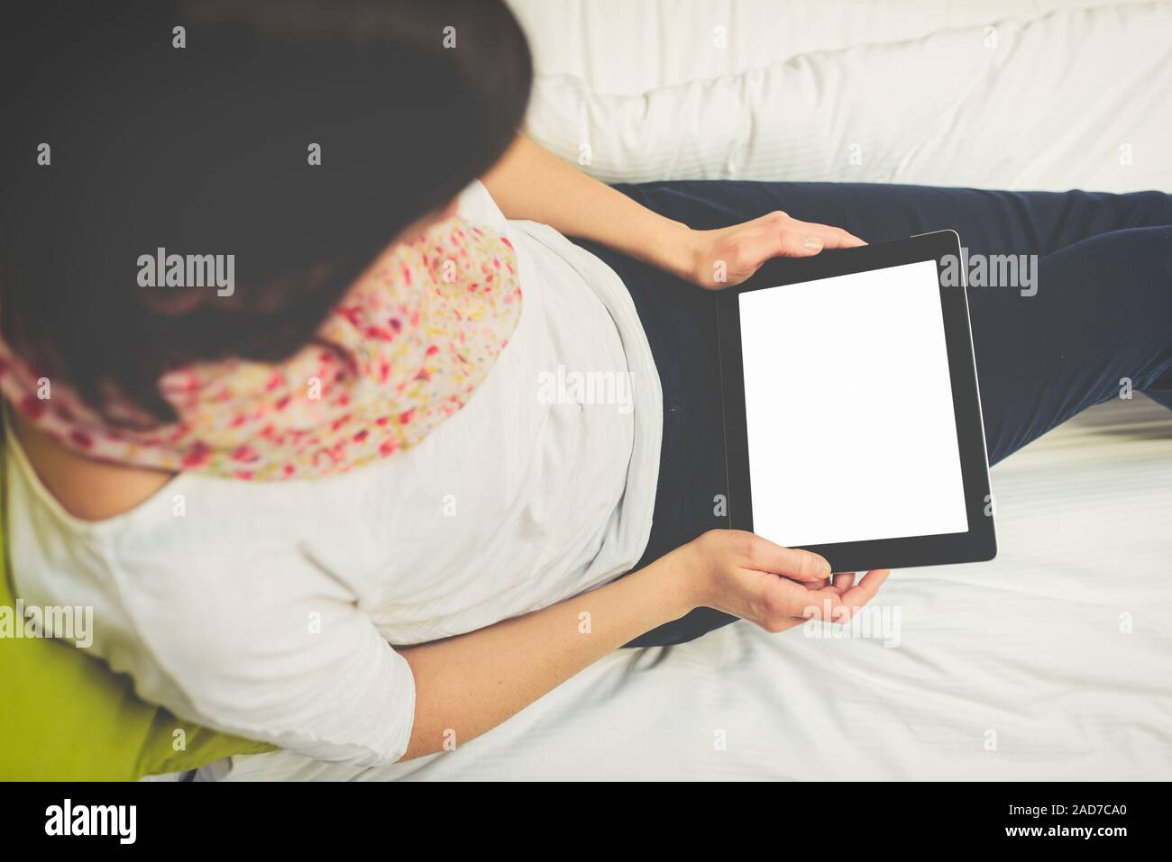 woman using tablet sitting on the bed Stock Photo