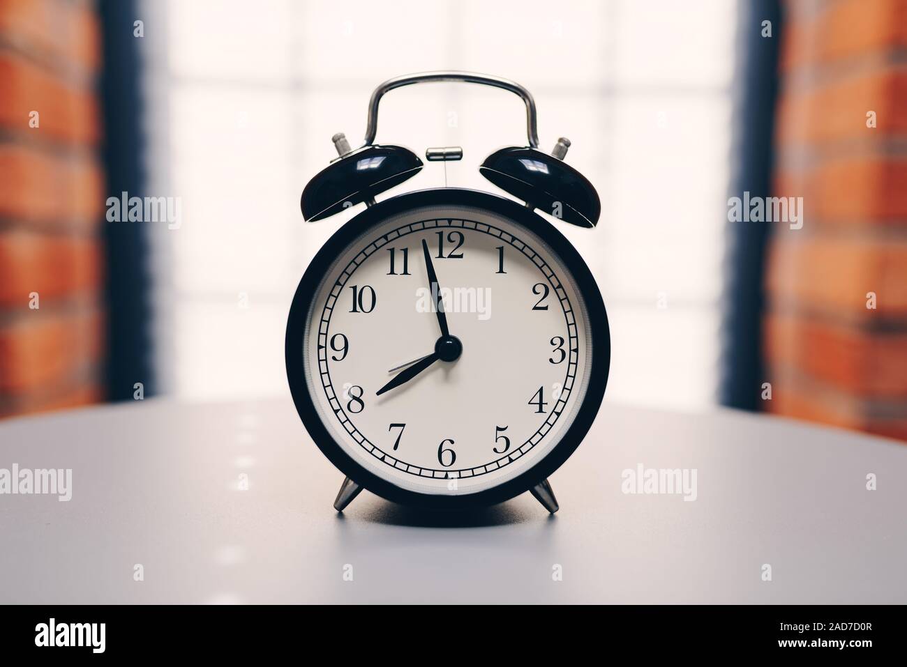 Retro alarm clock on table on white background Stock Photo - Alamy