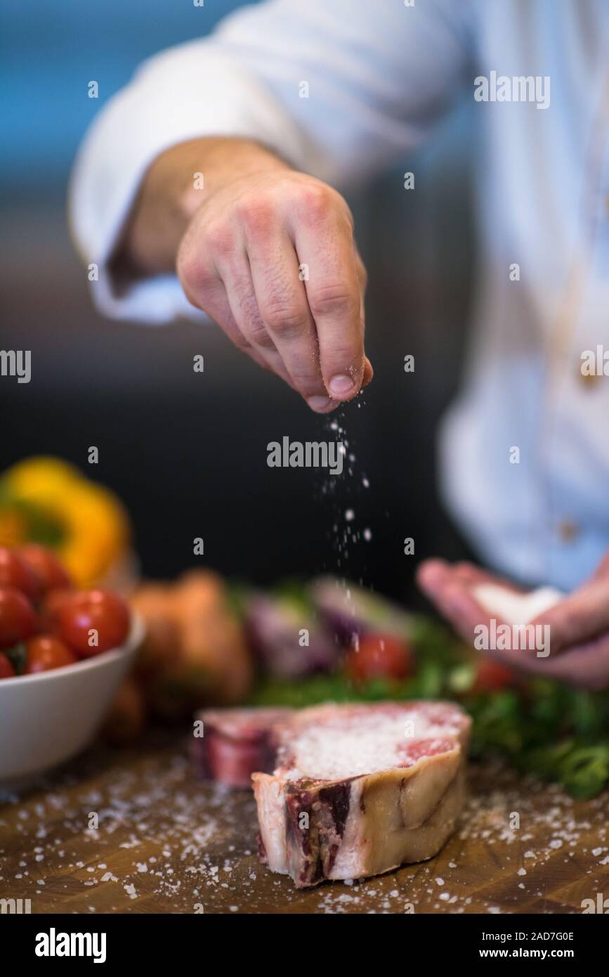 Chef putting salt on juicy slice of raw steak Stock Photo Alamy