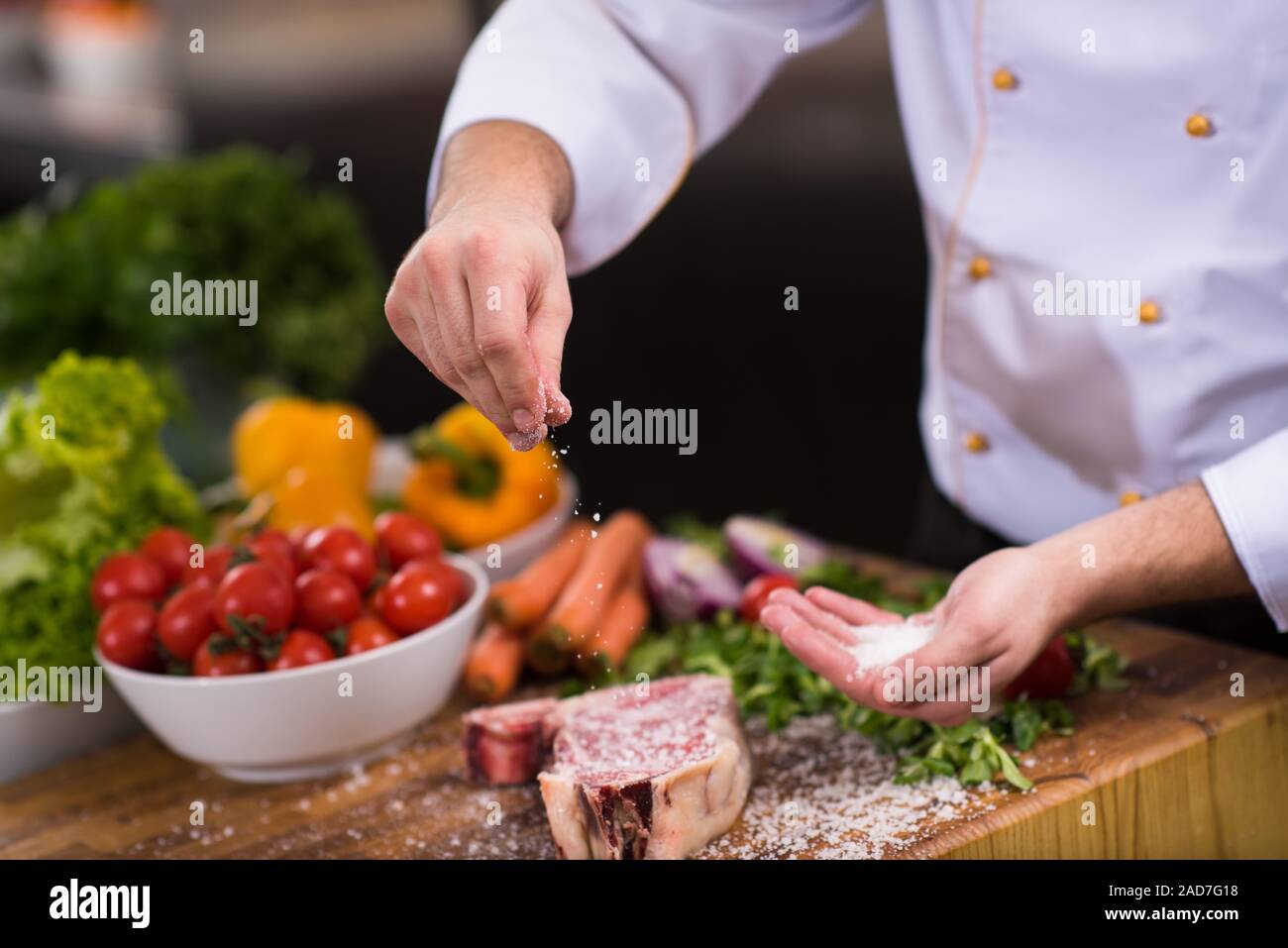 Chef putting salt on juicy slice of raw steak Stock Photo Alamy