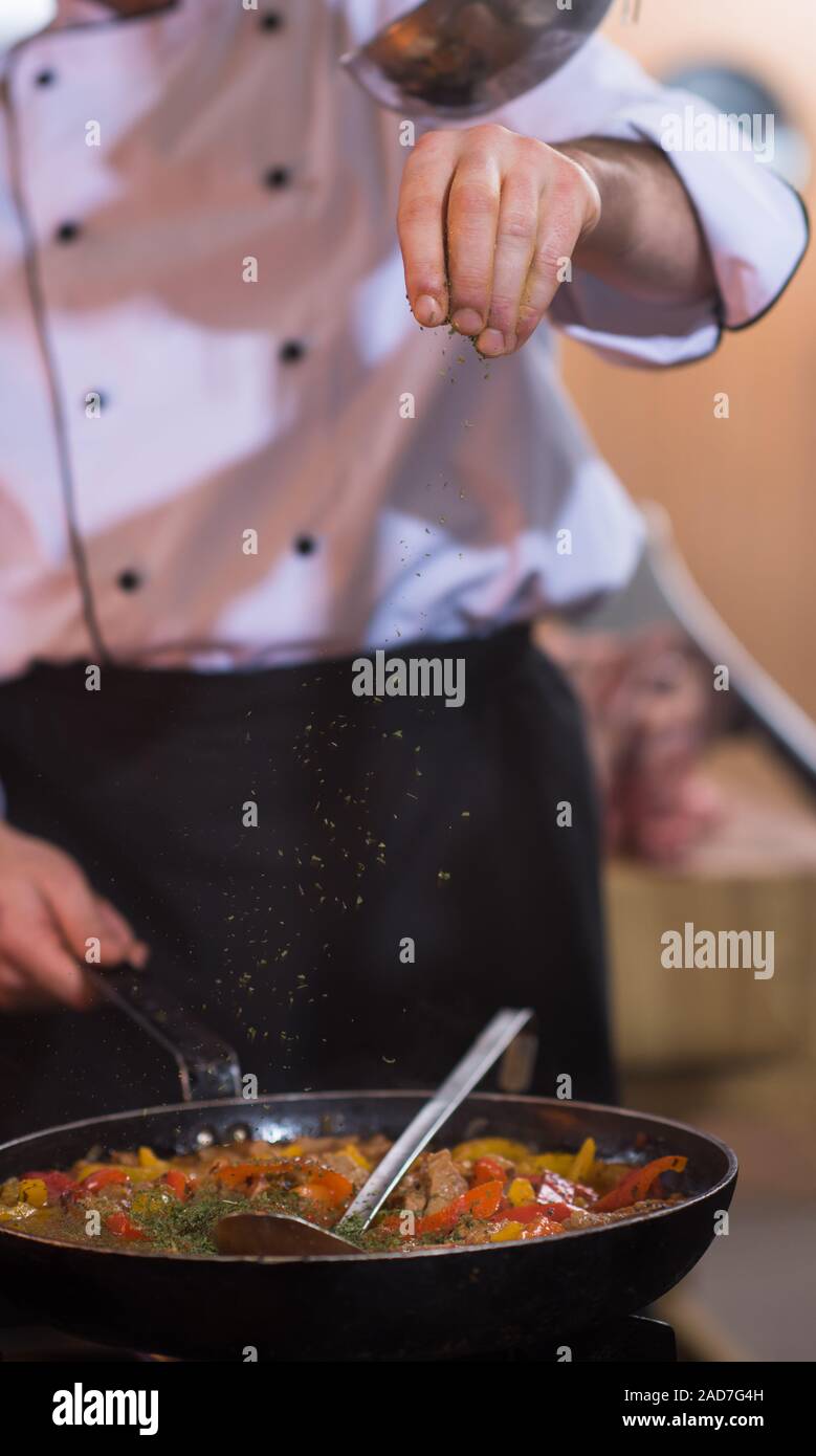 chef putting spices on vegetables in wok Stock Photo - Alamy