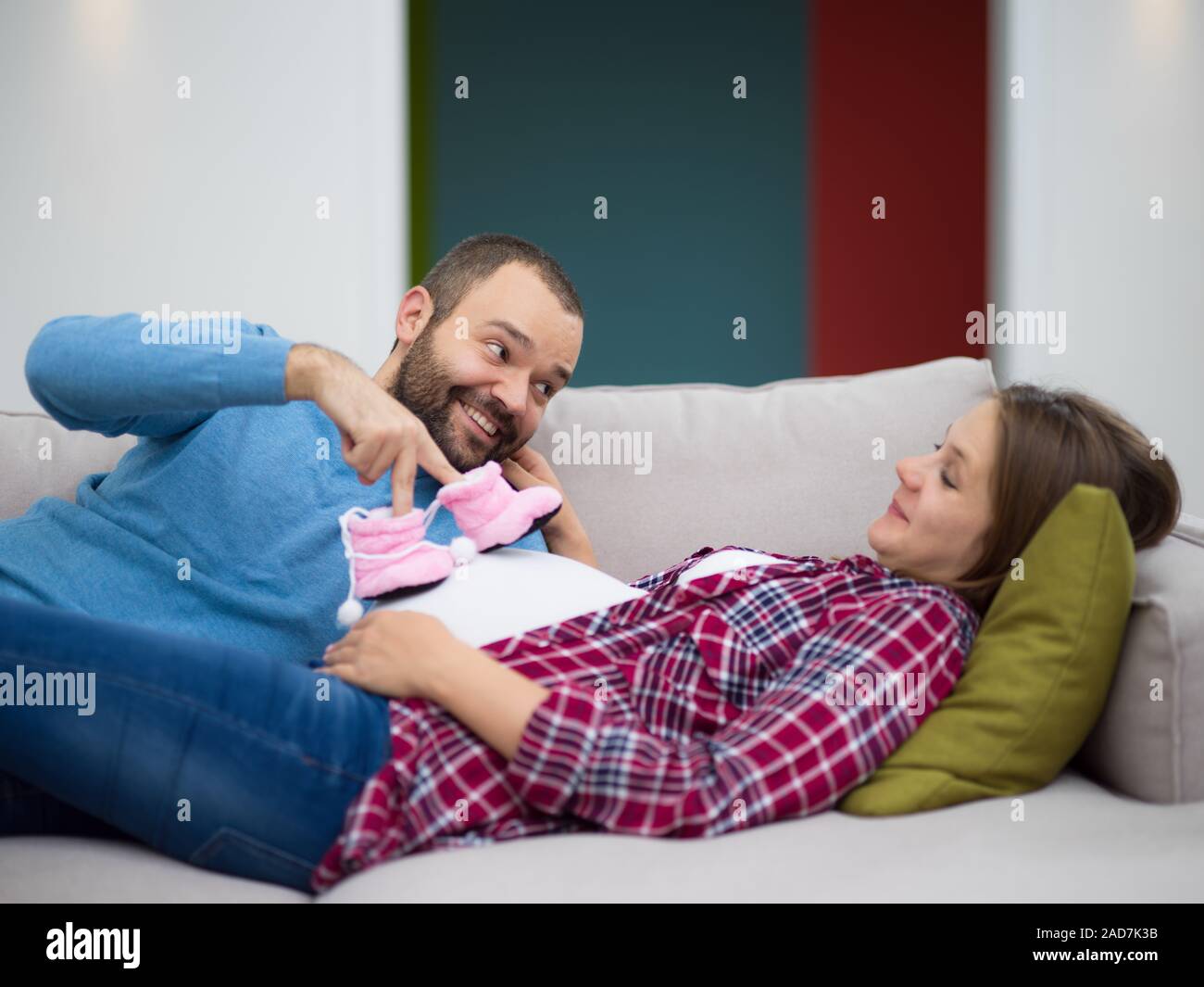 young pregnant couple relaxing on sofa Stock Photo