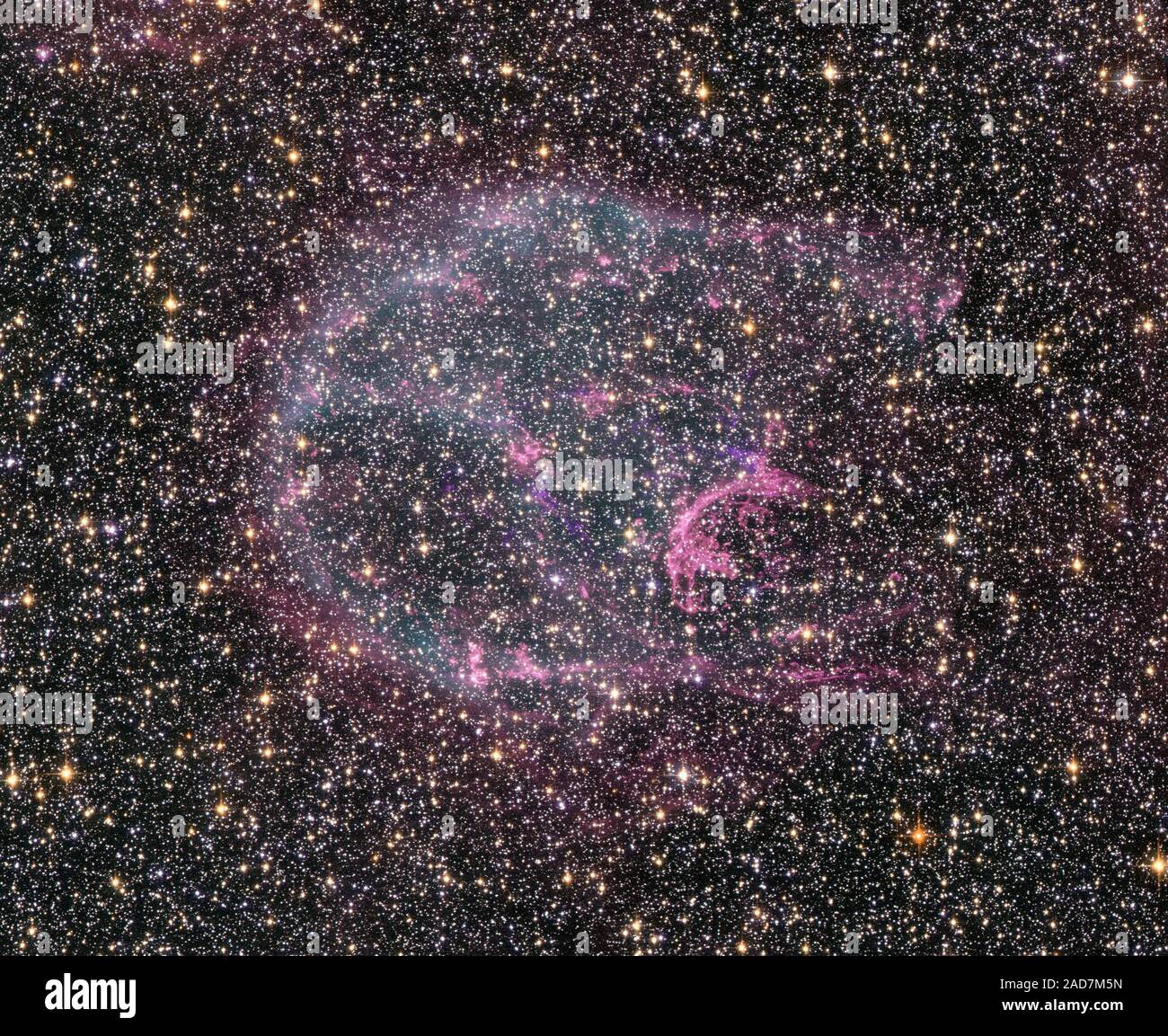 Intricate wisps of glowing gas float amid a myriad of stars in this image created by combining data from NASA's Hubble Space Telescope and Chandra X-ray Observatory. The gas is a supernova remnant, cataloged as N132D, ejected from the explosion of a massive star that occurred some 3,000 years ago. This titanic explosion took place in the Large Magellanic Cloud, a nearby neighbor galaxy of our own Milky Way.   The complex structure of N132D is due to the expanding supersonic shock wave from the explosion impacting the interstellar gas of the LMC. Deep within the remnant, the Hubble visible ligh Stock Photo